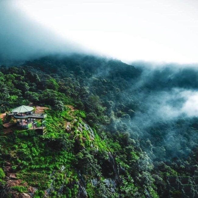 Panoramic view of lush green valleys and misty mountains at Bisle Ghat in Western Ghats"