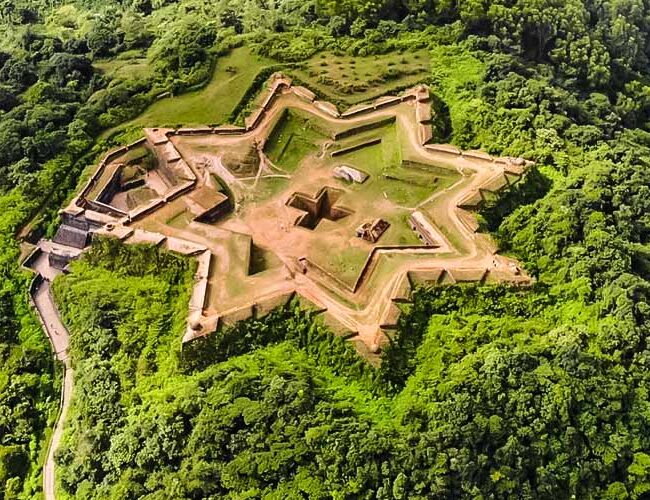 "Aerial view of star-shaped Manjarabad Fort surrounded by lush greenery in Sakleshpur"