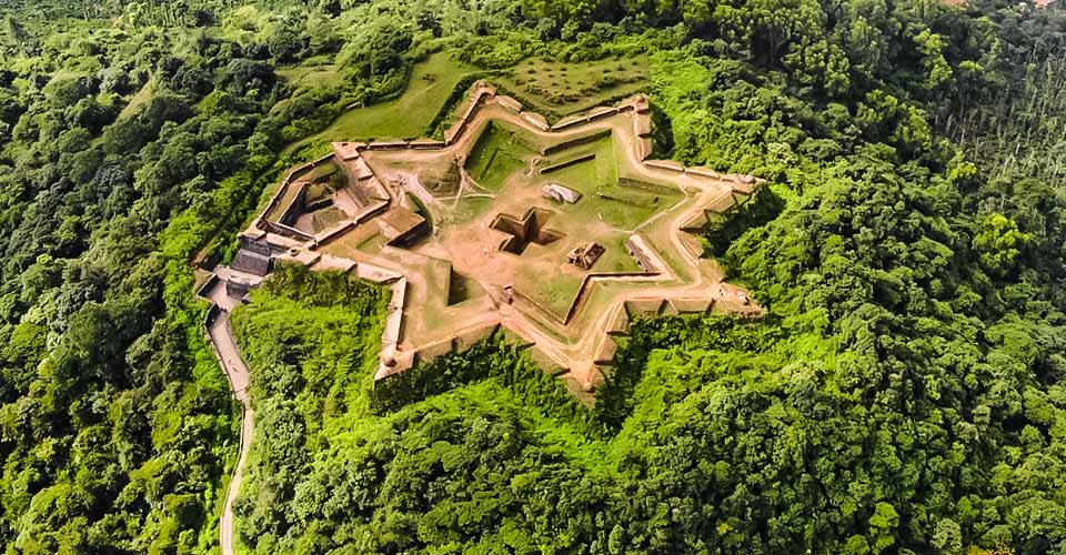 "Aerial view of star-shaped Manjarabad Fort surrounded by lush greenery in Sakleshpur"
